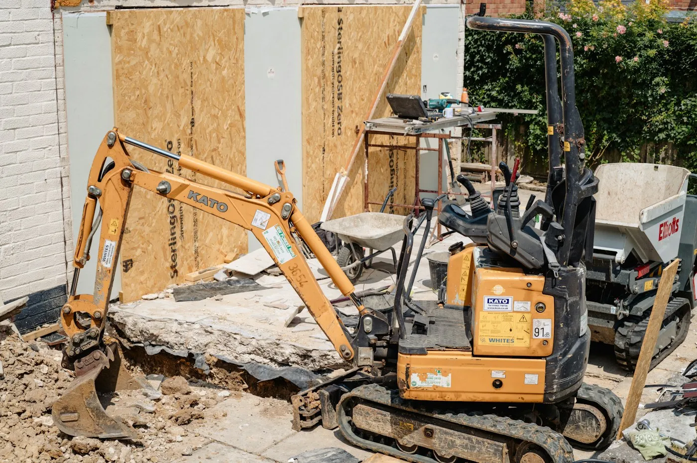 Compact excavator beside a building work area