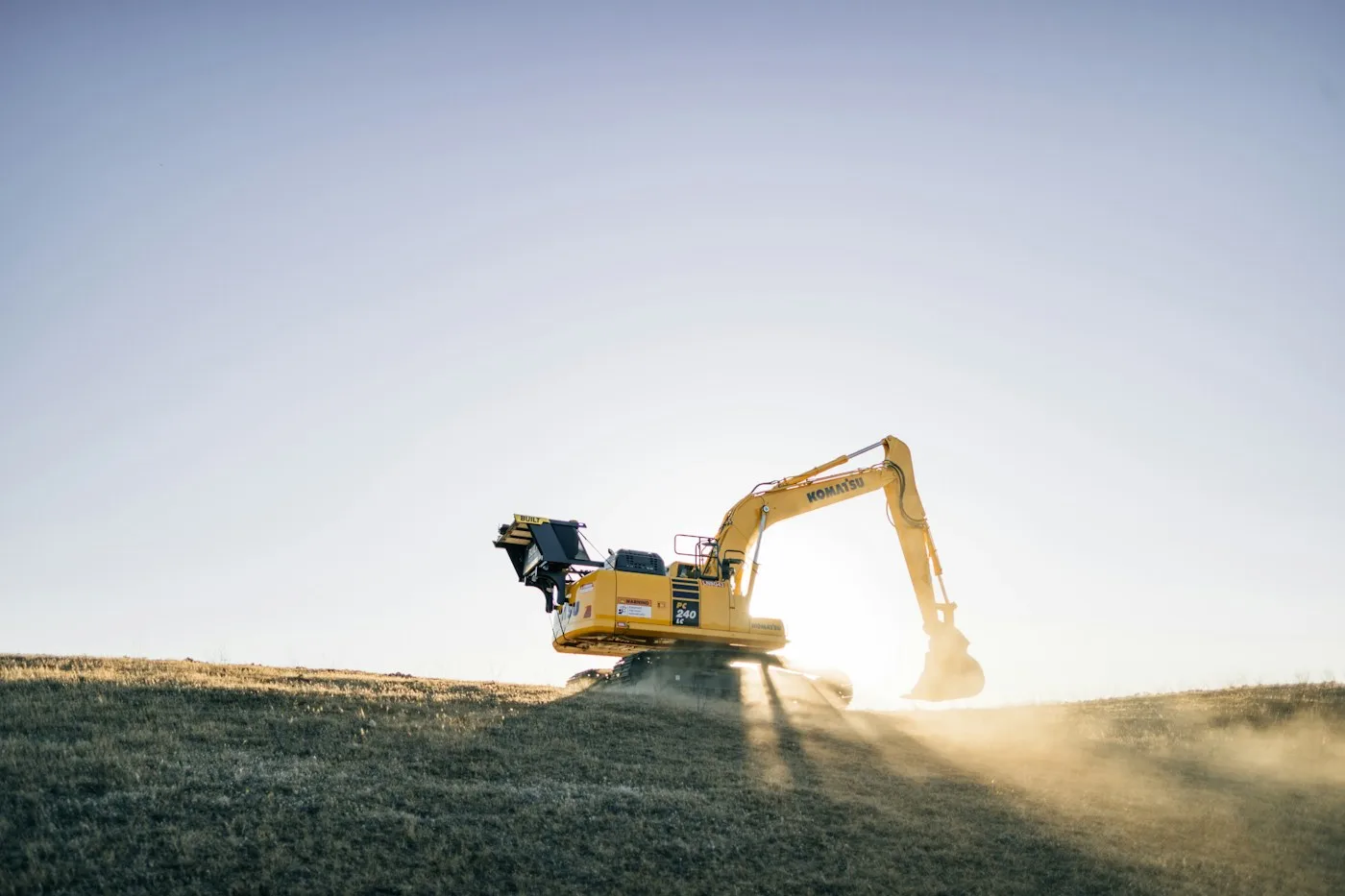 Excavator silhouetted on an open worksite